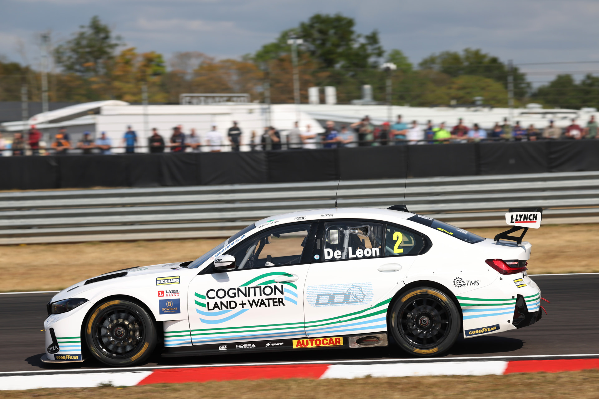 The #2 De Leon BTCC car passing spectators with supporter names on the door